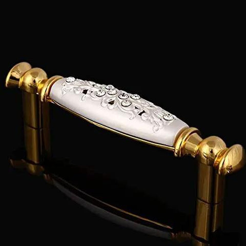 Modern 96Mm Cabinet Pull And Drawer Knob Featuring Crisp White Base With Dazzling 24K Gold Crystal Accent on a black background.