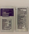 Two foil sachets of First Aid Only Triple Antibiotic Ointment; left has purple label, right shows drug facts.