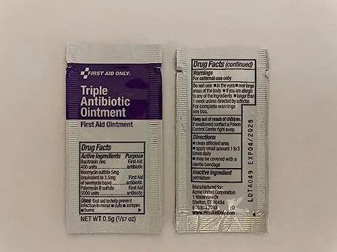 Two foil sachets of First Aid Only Triple Antibiotic Ointment; left has purple label, right shows drug facts.
