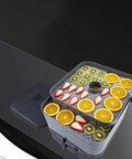 No Sweat Digital Food Dehydrator With Roomy Stackable Trays showing dried oranges and kiwi slices on trays.
