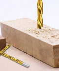 ENERTWIST titanium-coated drill bit drilling into a light brick block on a wooden surface