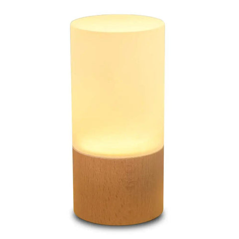 Cozy Beech Wood Table Lamp With Dimmable LED Light, glowing softly, cylindrical shape, compact design for bedside and desk use.