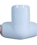 Close-up view of a One Half Inch PVC Tee Fitting 3 Way Elbow Connector Furniture Grade 90 Degree Side Outlet held by hand