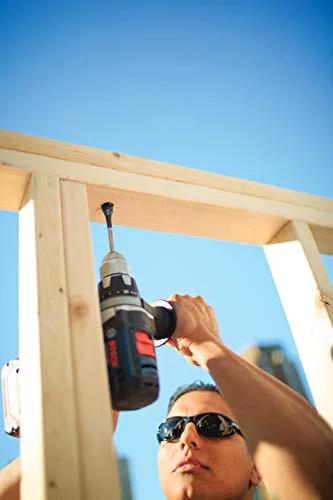 Blue cordless drill drilling into a wooden frame outdoors