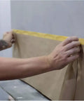 Applying Pro Grade Pre Taped Masking Paper With Adhesive, 20 Inch By 50 Feet Painter Paper Roll For Auto Body Masking on a wall