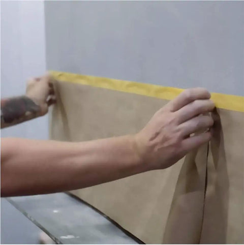 Applying Pro Grade Pre Taped Masking Paper With Adhesive, 20 Inch By 50 Feet Painter Paper Roll For Auto Body Masking on a wall