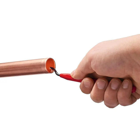 Hand using Reaming Pen Pro Grade Tool For Precision Hole Finishing on copper pipe, showing durable aluminum body and ergonomic grip.