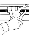 Exhaust manifold spreader installed between small-block Chevy exhaust manifolds; handheld tool.