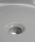 Close-up view of the USZWBY Vessel Sinks Ceramic Vessel Sink Simple Round Matte Gray with drain opening.
