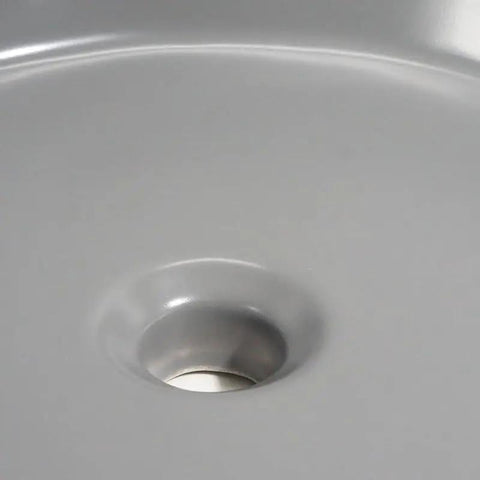 Close-up view of the USZWBY Vessel Sinks Ceramic Vessel Sink Simple Round Matte Gray with drain opening.
