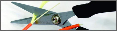 Six And A Quarter Inch Carbon Steel Shears cutting Kevlar and fiberglass, close-up on chrome pivot and black handle.