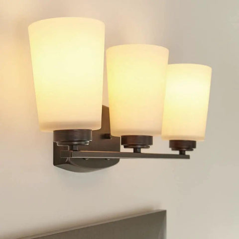 Three Light Wall Bath Fixture In Burnt Sienna Bronze Finish, Franport Collection, mounted above vanity, side view
