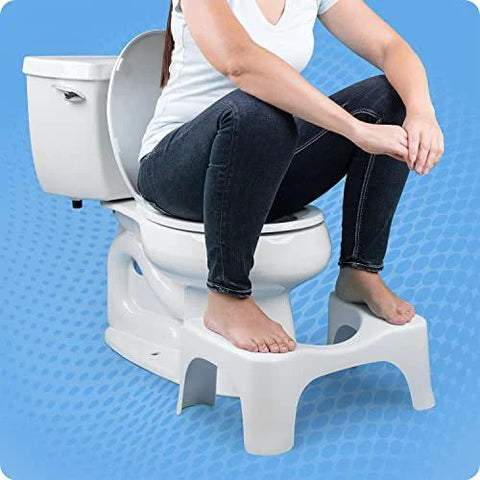 Front view of Squatty Potty Simple Curve 7-inch white toilet stool with user resting feet on it.