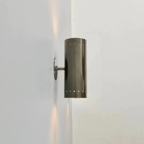 Perforated Brass Wall Sconce - Modern Cylinder Lamp mounted on wall, showcasing sleek cylinder design and decorative light patterns.