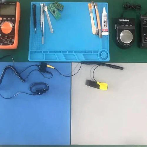 Front view of ESD grounding kit on blue anti-static table mat with wrist strap and ground cord.