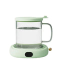 Electric Mug Warmer Coffee Cup Heater Coaster With Three Adjustable Heat Settings Keeps Your Coffee Piping Hot Without Drying Out. Clear glass mug on mint green heating base.