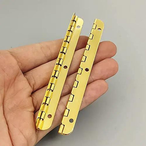 Two Pack Golden Metal Hinges For Cabinets And Furniture Hardware held in hand, showcasing antique vintage look for DIY repairs.