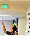 Person using Heavy Duty Extendable Safety Pole With Killer Reach Ditch The Ladder Smoke Alarm Tester And Fire Sensor Checker to check exit sign.