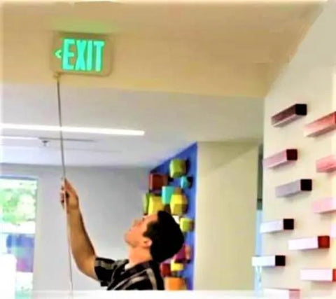 Person using Heavy Duty Extendable Safety Pole With Killer Reach Ditch The Ladder Smoke Alarm Tester And Fire Sensor Checker to check exit sign.