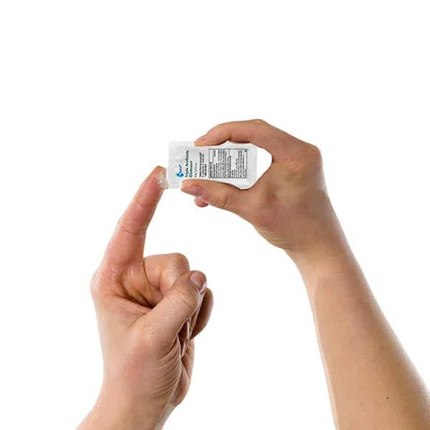 Triple antibiotic ointment single-use packet (0.9 g) held by hands.