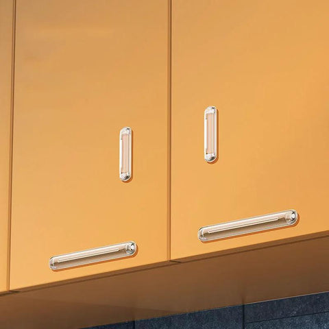 Eight clear silicone cabinet bumpers with adhesive installed on orange cabinet doors and drawers