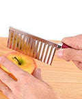 Potato crinkle slicer, stainless steel, cutting potato on wooden board in close-up