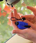 Blue Resqme emergency escape tool, 2-in-1 seatbelt cutter and window breaker with lanyard, hand-held inside car.