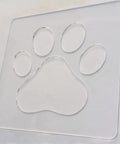 No Sweat Paw Print Router Template Crafted From Durable Clear Acrylic For Hella Easy Wood Inlays Charcuterie Boards Custom Signs And Quick Renovations Today, showcasing a transparent paw print design.
