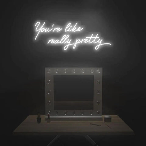 You're like really pretty neon sign above vanity table with mirror in dark room, LED neon tubing glowing softly.