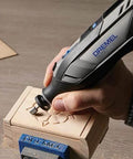Dremel 8250-5 cordless rotary tool with blue logo, carving wood in a vise (close-up).