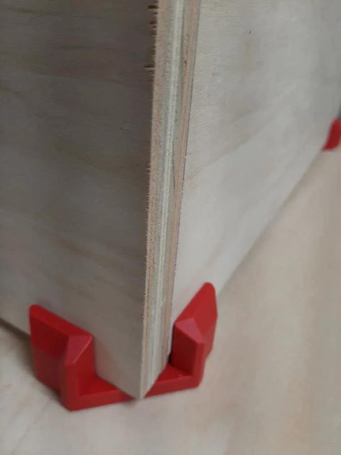 Close-up of 4 Pack Right Angle Corner Clamps For Cabinet Making And Box Assembly, securing a wooden board at a 90 degree angle.
