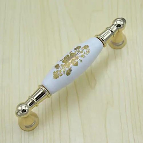 A Premium 96mm Center To Center Cabinet Drawer Pull And Ceramic Porcelain Knob With Slick White Gold Accents on wood background.