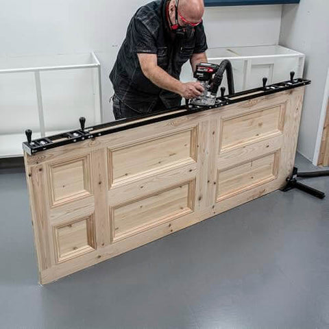 Person using All-In-One Adjustable Door Hinge Jig Installation Kit For 2 Ft 6 In To 9 Ft Doors with router on wooden door.