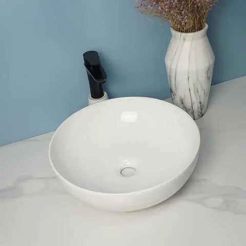 USZWBY Vessel Sinks Modern Simple Round Sink Home Bathroom Above Counter Basin with black faucet and white marble vase.