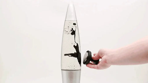 Hand using magnet on Retro Rocket Ship Ferrofluid Lava Lamp With Magnetic Black Wax In Clear Liquid, 15 Inch Tall, Silver Aluminum Base And Cap