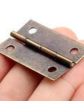 Close-up of a 34x22mm antique-style decorative furniture hinge held in hand, part of the 4 Pcs 34x22mm Decorative Furniture Hinges Set For Cabinets And Cupboards With Screws Antique Style Door Hinges For Jewelry Boxes Wooden Boxes Dressers And Shelves Tough As Nails.