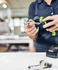 Person assembling a Badass Cordless Drill Driver Featuring Ec Tec Brushless Motor High Torque Heavy Duty Power Tool on a workbench.