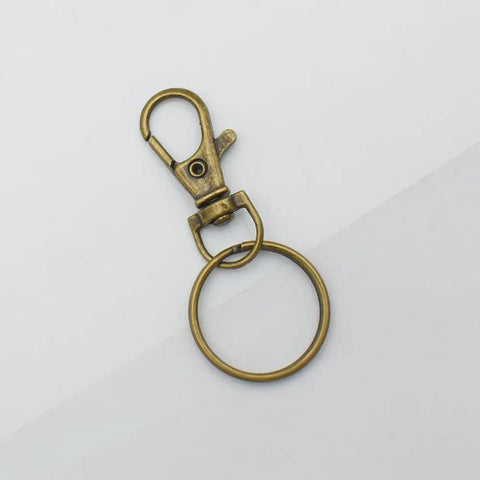 60 Pack Bronze Swivel Clasps Featuring Lanyard Snap Hooks With Key Rings Plus Lobster Claw Clips For Jewelry Making And Diy Crafts Hella Durable Zinc Alloy Construction Smooth 360 Spin Action Badass Quality That Lasts - close-up view of single clip with key ring.
