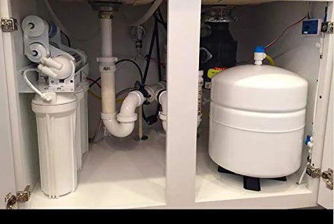 Under-sink RO system installed with two white filter housings and a white expansion tank.