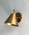 Handcrafted Brass Wall Sconce with Finial Vintage Hardwired Light shown in brass with a cone-shaped shade and decorative finial.