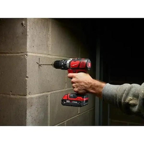 Rock Solid One Half Inch Cordless Compact Hammer Drill Driver Kit featuring all metal gear case drilling into a concrete wall.