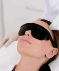Legit Heavy Duty IPL Laser Safety Glasses With Solid Eye Protection And Broad Spectrum Shielding Against Ultraviolet Blue Light And Infrared Beams For Laser Hair Removal Treatment on a woman during a procedure.