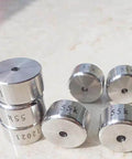 Inlet poppet valve components for waterjet; set of stainless steel discs with central holes, front view, marked 55K.