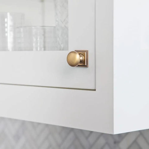 Brushed Brass Cabinet Knob With Backplate on white cabinet, part of Six Pack Zinc Alloy Durable Single Hole Center Mount Pull Hardware