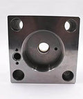 Waterjet intensifier end bell assembly; black metal square plate with central boss and four mounting holes