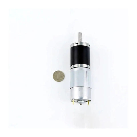 Heavy Duty 42mm Planetary Gear Motor With 775 Brushed DC Drive next to a coin for size comparison, showing its compact design.