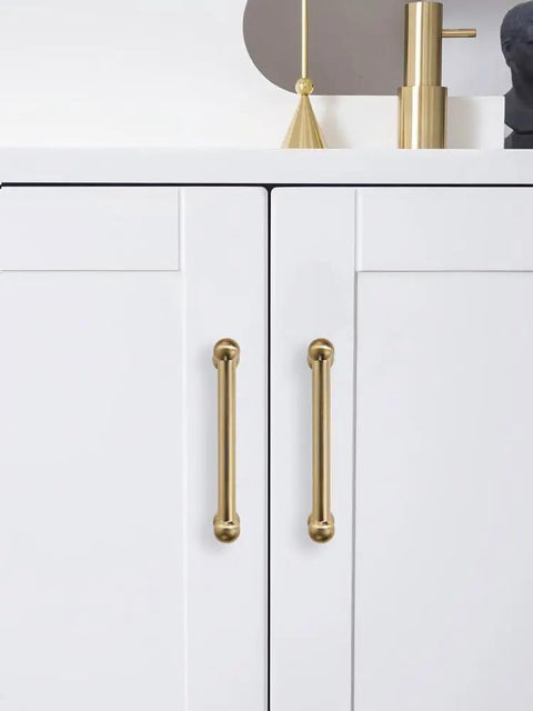Premium Solid Brushed Brass Cabinet Pulls And Drawer Handles 3 Inch Hole Center on white cupboard doors with a sleek design.