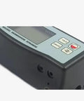Close-up of digital profilometer surface roughness tester with diamond stylus probe, shows buttons and display interface.
