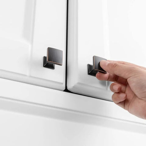 Person installing Ten Pack Small Oil Rubbed Bronze Cabinet Knobs Square Single Hole Pulls For Cabinets Drawers Dresser Cupboard Bedroom Closet Bathroom Easy Install 25mm 0.98 Inch Knob Size Kit With Mounting Hardware on a white cabinet.