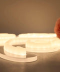 Close-up of Better Together Neon Sign Set Two LED Wall Decor Signs In Warm White with safe silicone tubes on a flat surface.